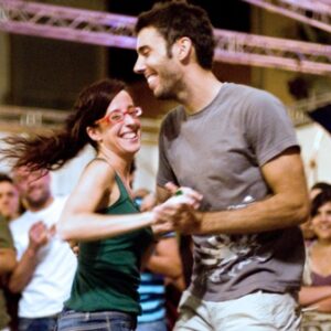 A happy, young couple engaged in swing dance, including lindy hop, after lessons